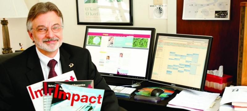 Dean Darrell Radson holding copies of Impact