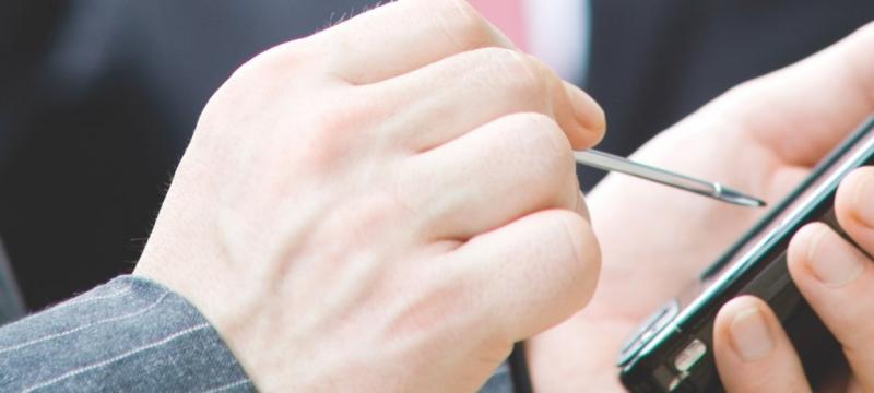Hands using a stylus on a device.