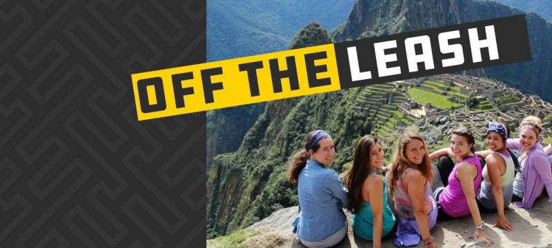 Students sitting on a wall overlooking mountains.