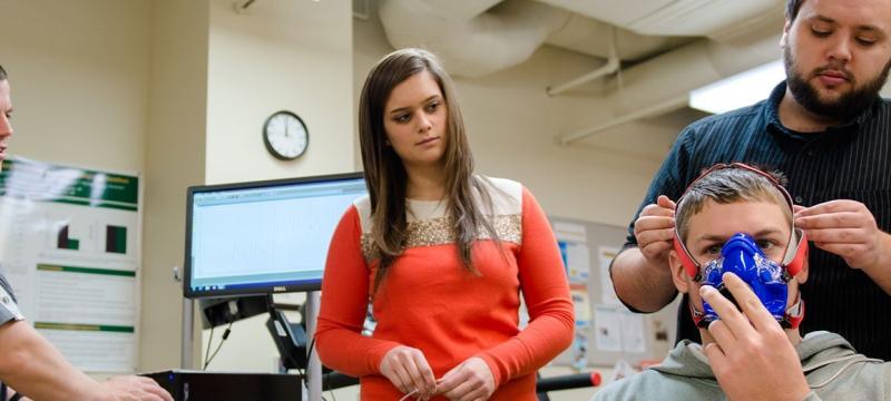 Researchers putting a breathing mask on a person.
