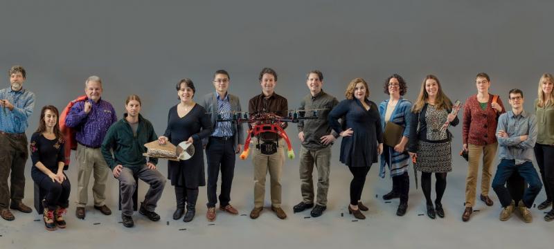 Fourteen researchers standing and sitting in a row.