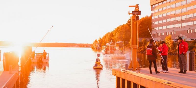 Researchers standing on the dock at the Great Lakes Research Center.