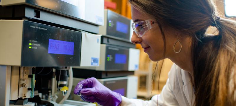 Student putting a sample into a machine.