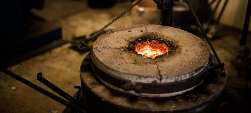 Crucible in the foundry with molten metal glowing inside.