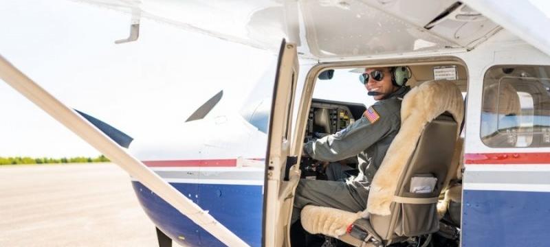A pilot in a flight suit in his plane at Houghton Country Memorial Airportâ€”he is a Michigan Tech ROTC cadet, too, and super active on campus.