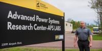 The 2022 Michigan Tech Research Award Winner stands in front of the APS LABS sign outside one of the research facilities he oversees.