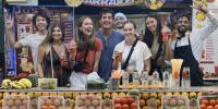 Eight young people at a smoothie stand while studying abroad, including a Michigan Tech Husky, Sophie Mehl, second from left