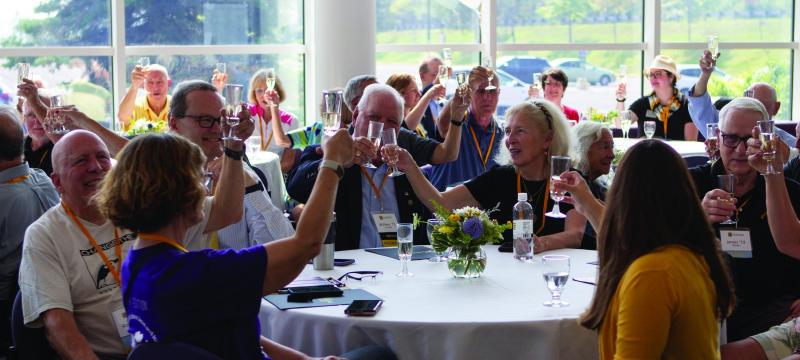 People at tables toasting during the Golden M ceremony at Alumni Reunion.