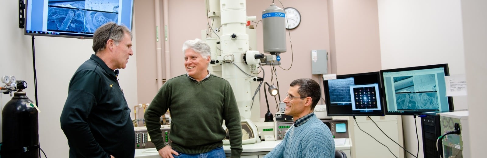 Two researchers discuss results on a moniter from an electron microsope