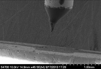 A stream of ions from a jet fuel form a needle-like tip in this SEM image.