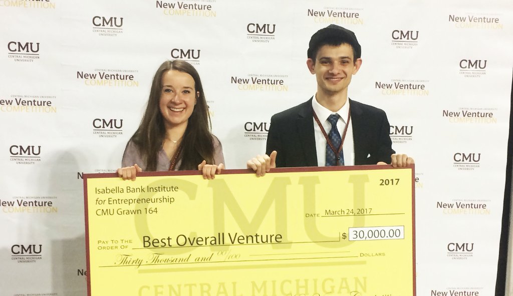Morgan Crocker and Nick Dubiel pose with the top prize in the New Venture Competition held at Central Michigan University in March.