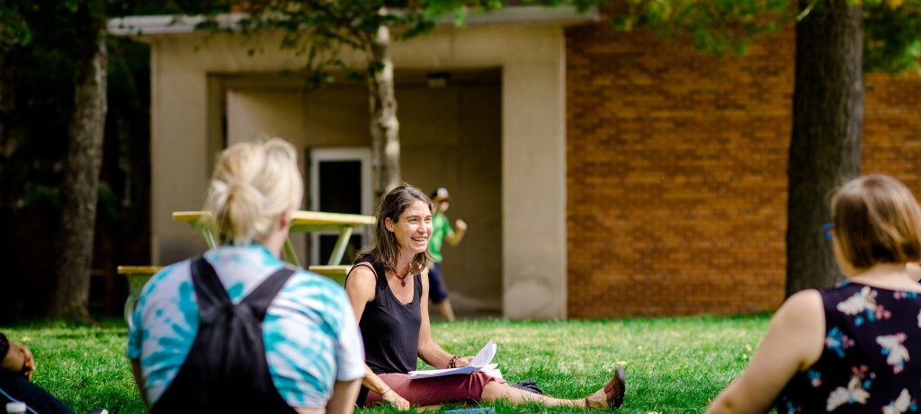 Faculty member and community advocate Richelle Winkler on the campus lawn with her students.