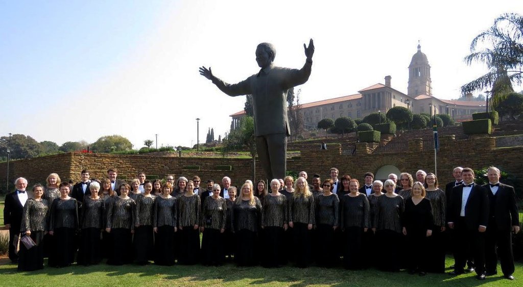 The Michigan Tech Concert Choir, under the director of Jared Anderson, far right, poses in front of a statue of Nelson Mandela in Pretoria, South Africa in May.