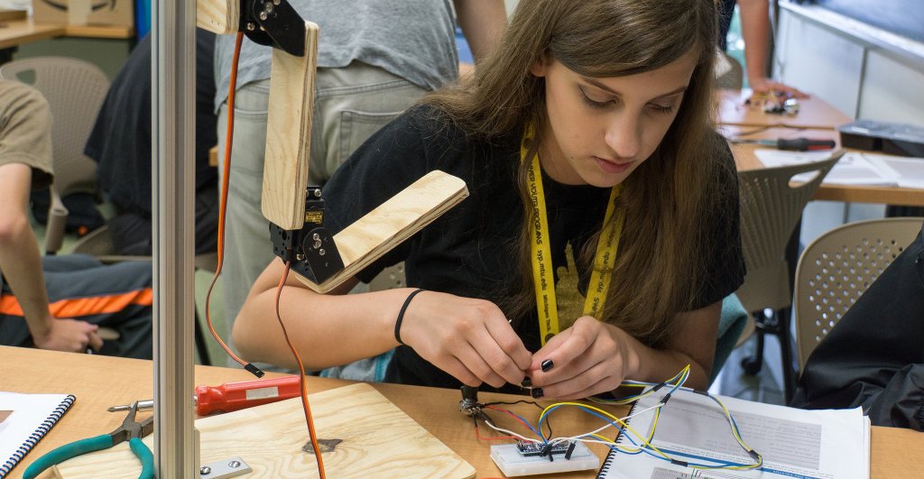 Kate Magnuson, who will be a high school freshman this fall in Wausau, Wisconsin, works to assemble the Neu-pulator robotic arm that reads cues from muscle sensors attached to a human arm during the co-ed version of the camp Robotics 101 last week. Image Credit: Nathan Miller