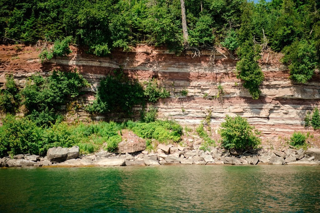 Geotourists examine variegated sandstone cliffs from the deck of Michigan Tech Research Vessel Agassiz.