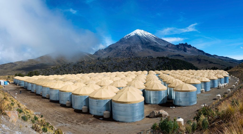 The HAWC Observatory sits at an elevation of 13,500 feet, flanking the Sierra Negra volcano inside Pico de Orizaba National Park in the Mexican state of Puebla. Its more than 300 water tanks can detect cascades of particles initiated by high-energy packets of light called gamma rays. Image Credit: HAWC