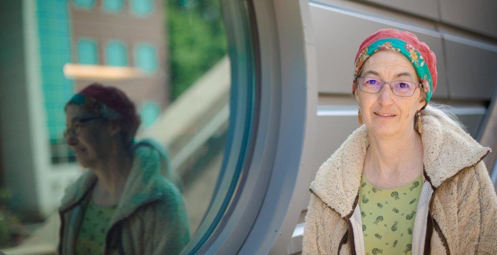 professor Sarah Green stands in front of a round window at the Great Lakes Research Center