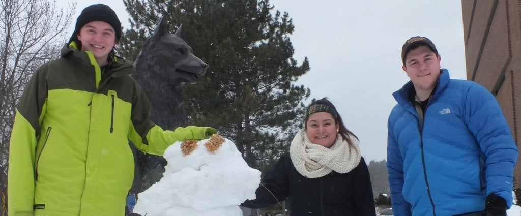 Undergraduate students Jack Ivers, John Nowosad and Karina Aranda practice snowman building on Husky Plaza.