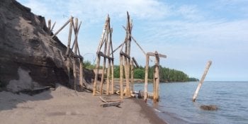 The historic wooden sluiceway stands on the shoreline where the sands that covered it have eroded away.