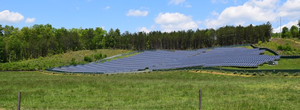 An array of solar panels in a field.