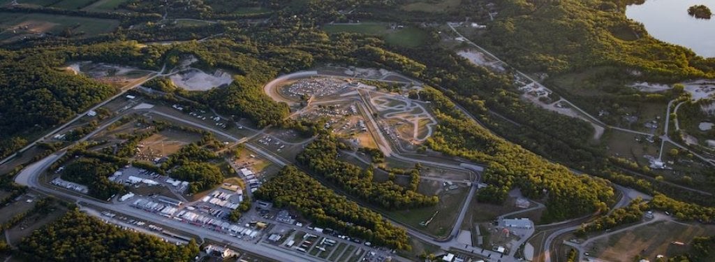 Aerial view of test tracks with rectangular straight-aways and a curving route circled by trees