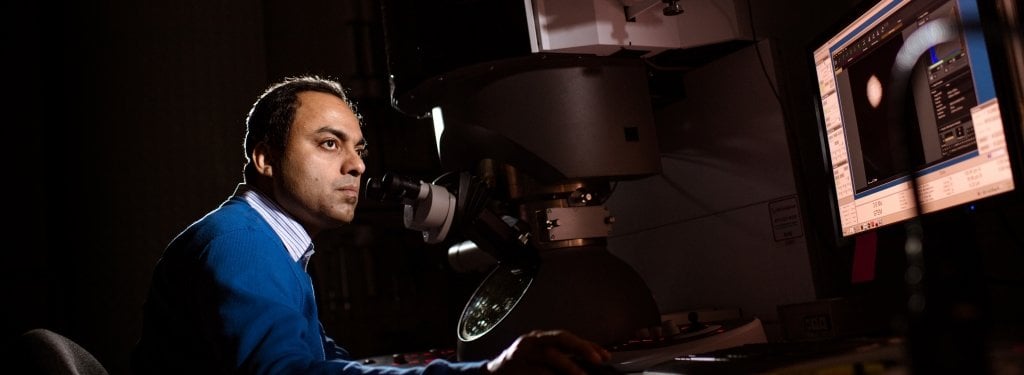 Pinaki Mukherjee looks at an image on the computer processed by the scanning transmission electron microscope.