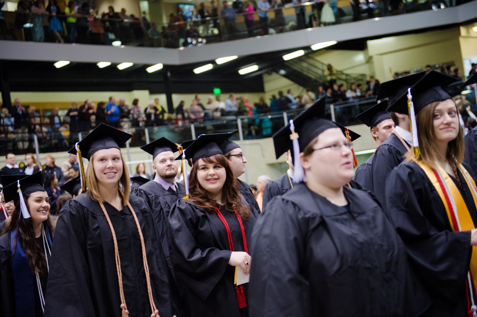 Women students in graduate caps and gowns at commencement. 