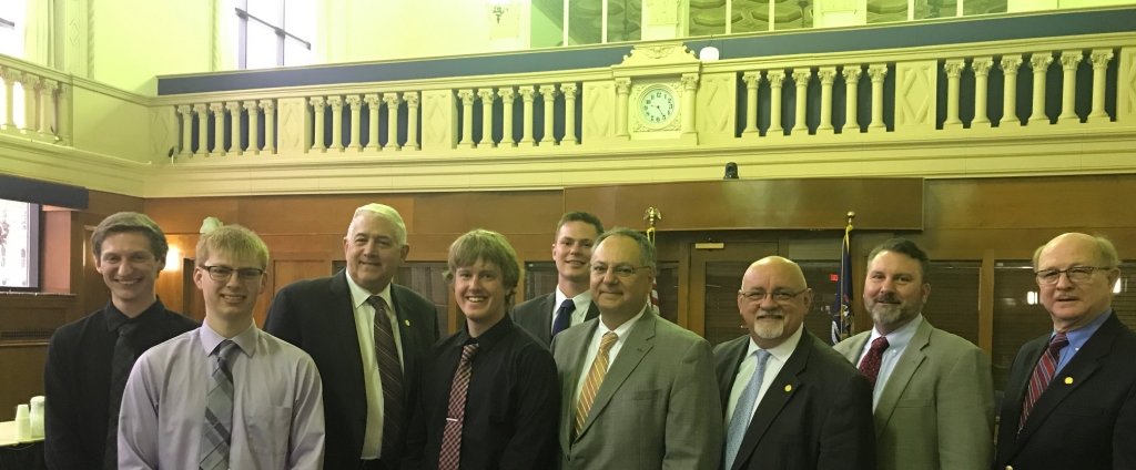Michael Prast, Gavin Bodnar, Jeremy Dziewit and Aaron Crapsey with industry advisor Jim Morrison, fourth from right, and lawmakers, including acting chair Senator Horn, third from left. (Design team photo)