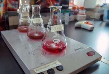 Beakers with liquid in them on a scale in a lab.