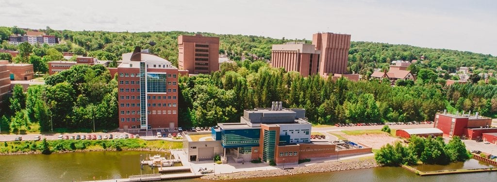 Michigan Tech's campus from across the Portage Canal. Featuring the ME-EM building in the background, above the tree-line.