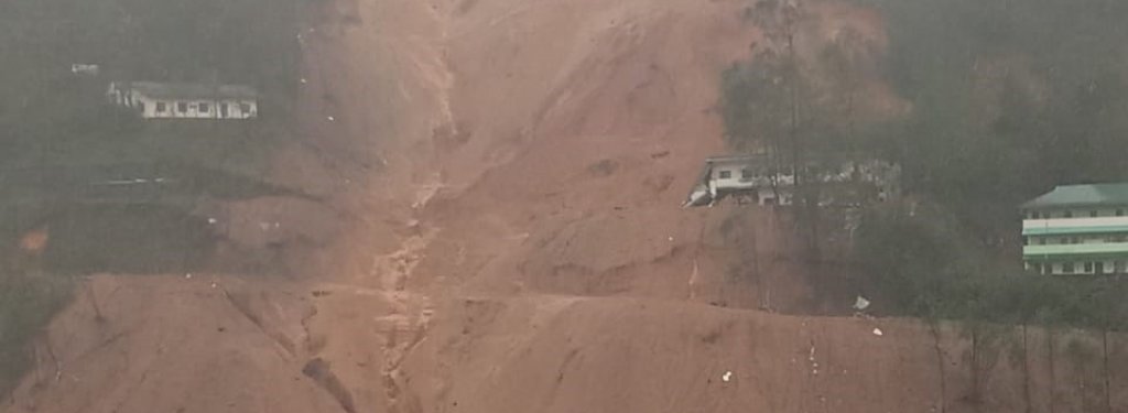 landslide gouge in a steep hill reveals red-brown sediment