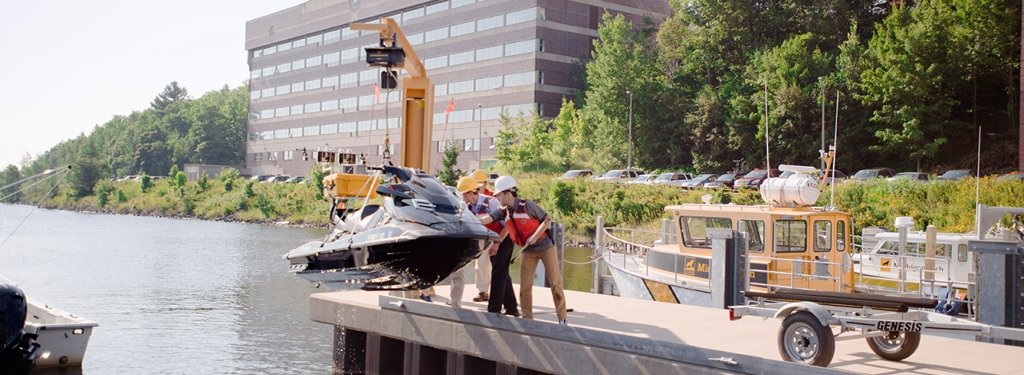 Great Lakes Research Center personnel lower an autonomous watercraft into the water at the GLRC dock, Aug. 10. The vessel was used as a demonstration during the launch of the Smart Ships Coalition and Marine Autonomy Research Site (MARS).