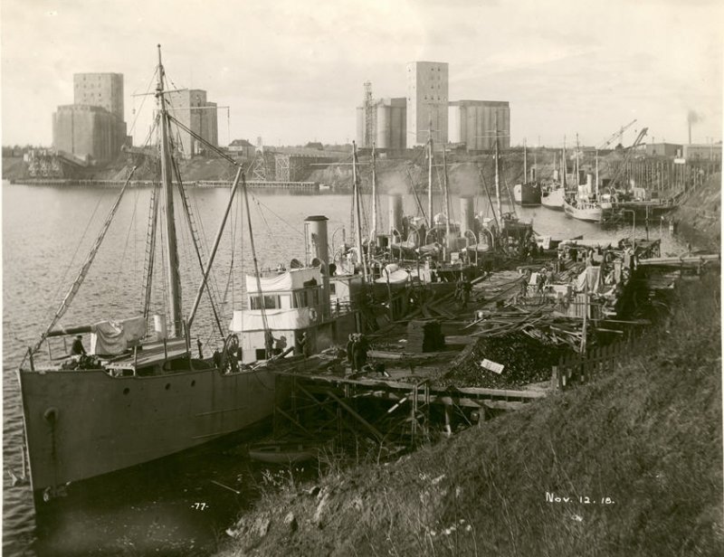 Newly built and outfitted minesweepers at the dock in a black and white photo from 1918 in a harbor on lake superior