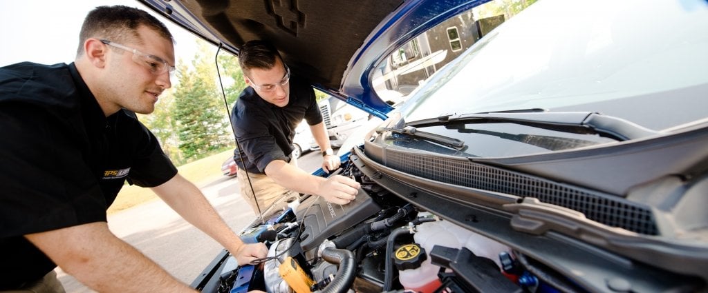 two men looking under the hood of a car