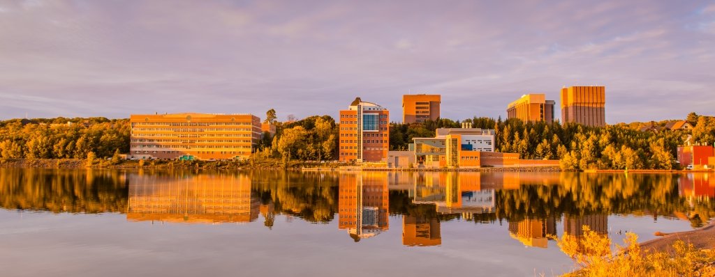 Michigan Tech campus in fall reflected off Portage Canal