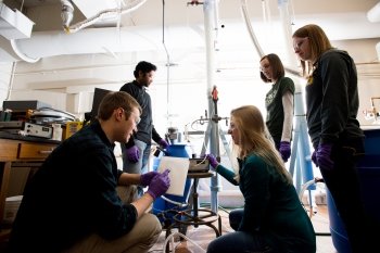 team of students around a cylindrical tower