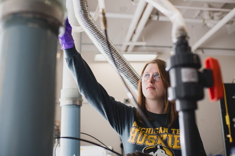 young woman adjusts a valve