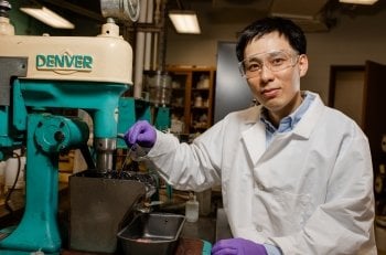 A portrait of a Lei Pan, a man wearing a white lab coat.