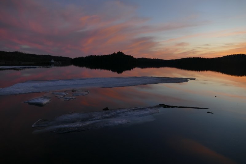 Sunset on a lake with melting ice