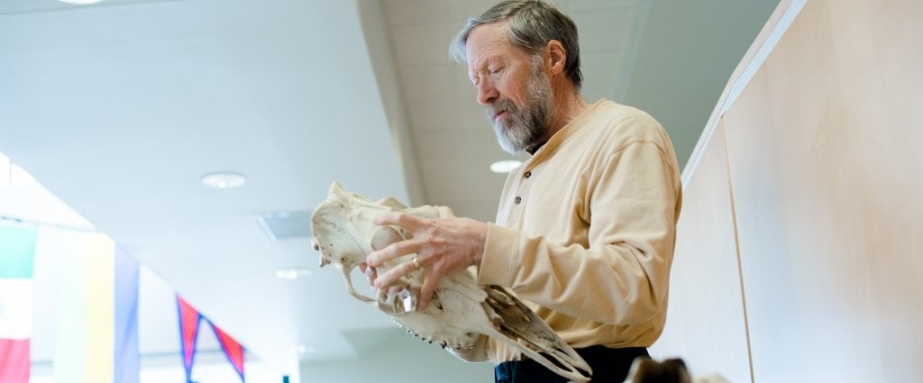 man holding moose skull