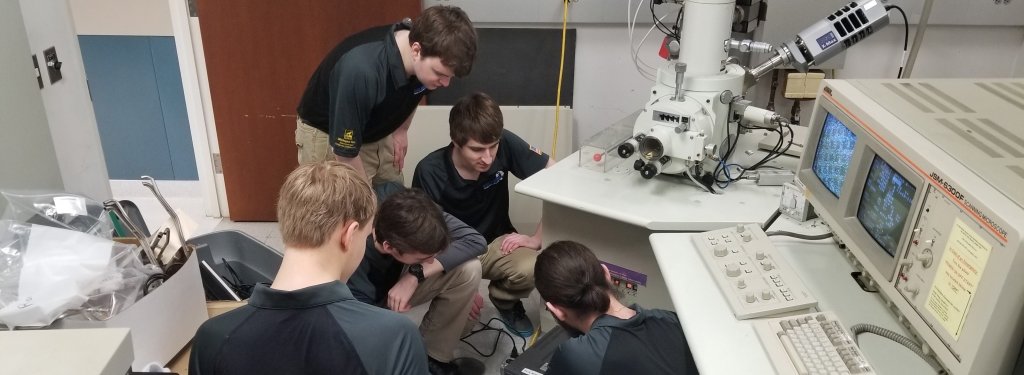 Members of Blue Marble Security work on a project which allows scanning electron microscopes (SEM) to replace old cathode ray tube (CRT) monitors with modern LED monitors.