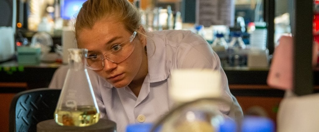 student looking at a flask 