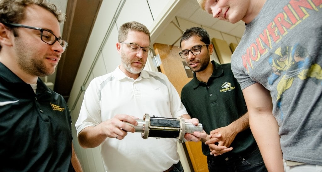 Andrew Barnard, second from left, and students examine item. 