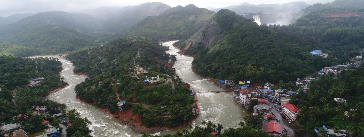 View of the three open shutters of the Cheruthoni Dam in the background. Evidently, the Cheruthoni Bridge has been destroyed due to flood waters. Image Credit: I&PRD drone image of a swollen riverbed