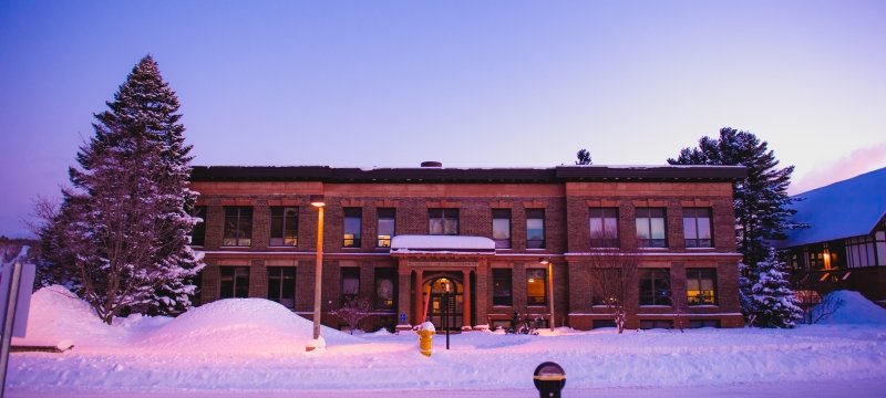 Exterior of Michigan Tech's College of Business in winter at dusk