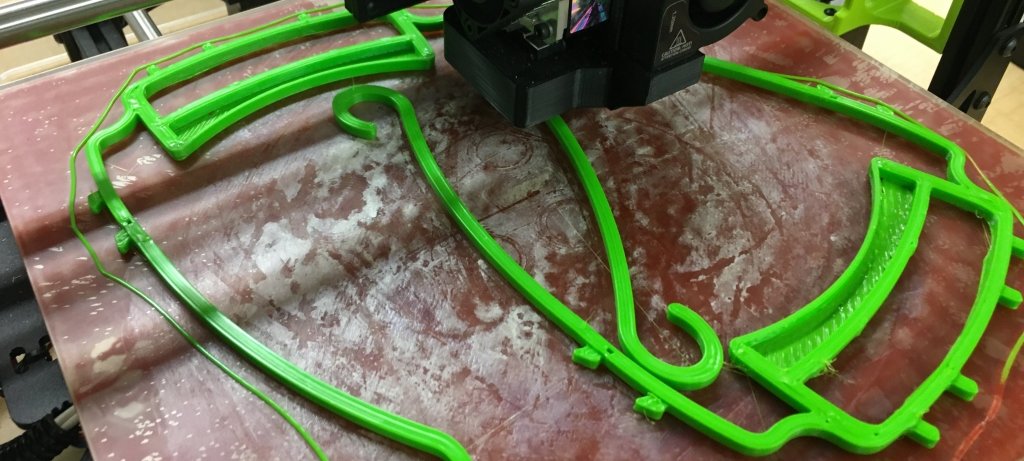 A 3-D printed face shield armature on a printing surface close up.