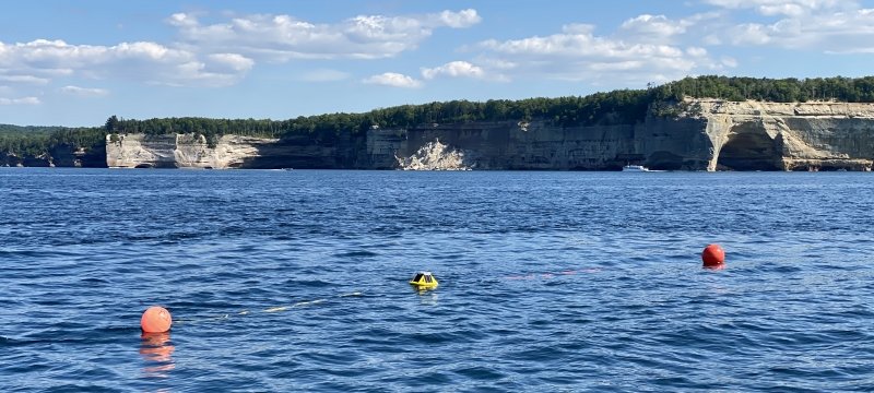A Spotter buoy in the water near the cliffs of Pictured Rocks.