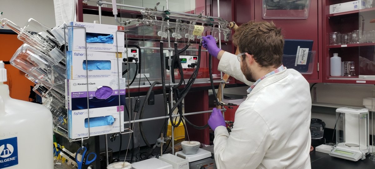 A person hooks up laboratory equipment.