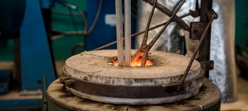 A hot forge holds bars of raw aluminum. 