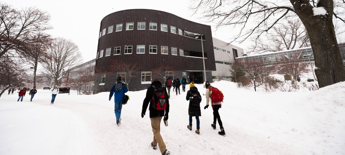 Campus view of Rekhi Hall and walkways in winter. 
